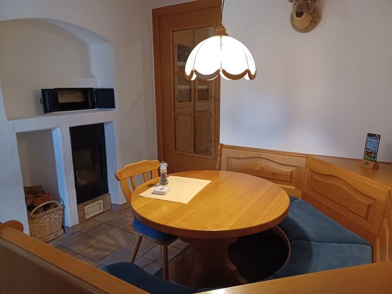 Ecke mit Ofen und rundem Tisch im Aufenthaltsraum