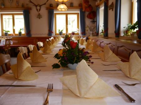 Festlich gedeckte Tafel mit gefalteten Servietten und Blumenstrauß