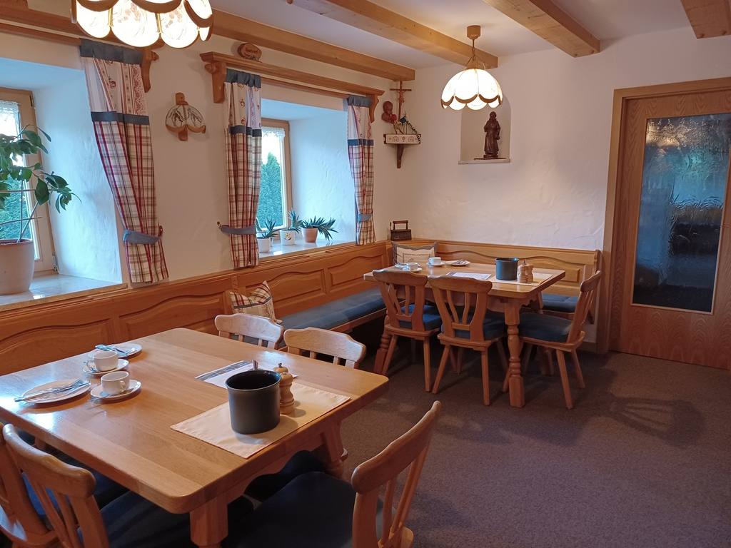 Frühstücksraum mit Holztischen und Tiroler Eckbänken