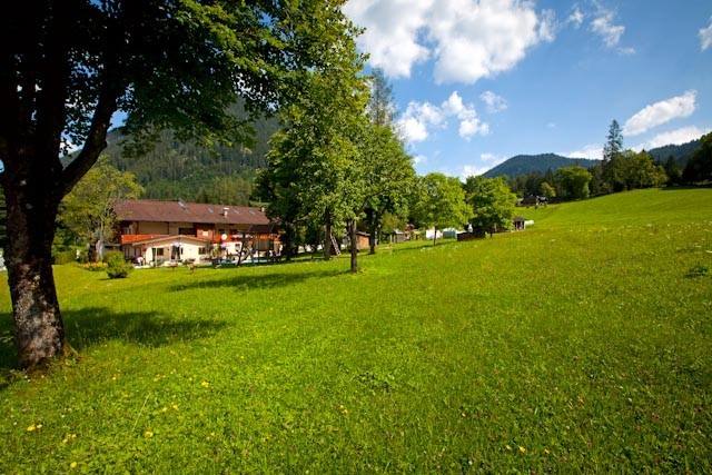 Wiese und Spielplatz vor dem Gästehaus mit Bergkulisse