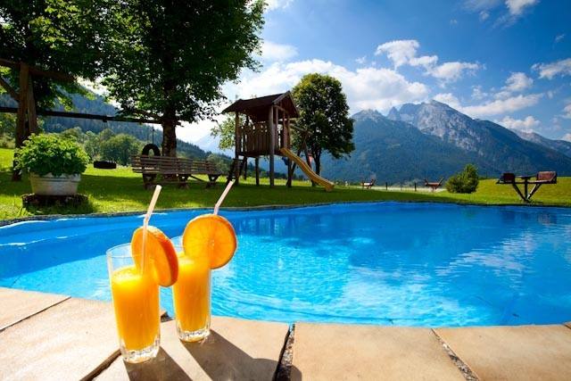 Pool mit Orangensaft und Spielplatz – Garten des Gästehauses