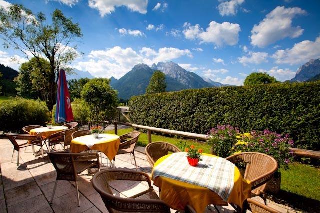 Terrasse mit gedeckten Tischen vor dem Gästehaus