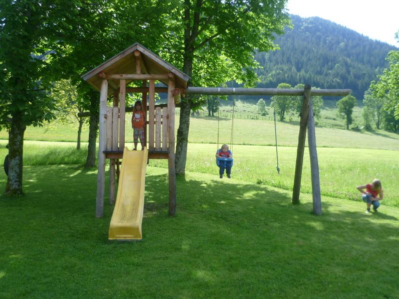 Spielplatz mit Rutsche und Schaukel im Garten des Gästehauses