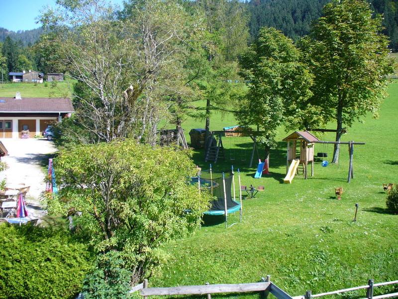 Blick vom Spielplatz auf den Garten und das Haus