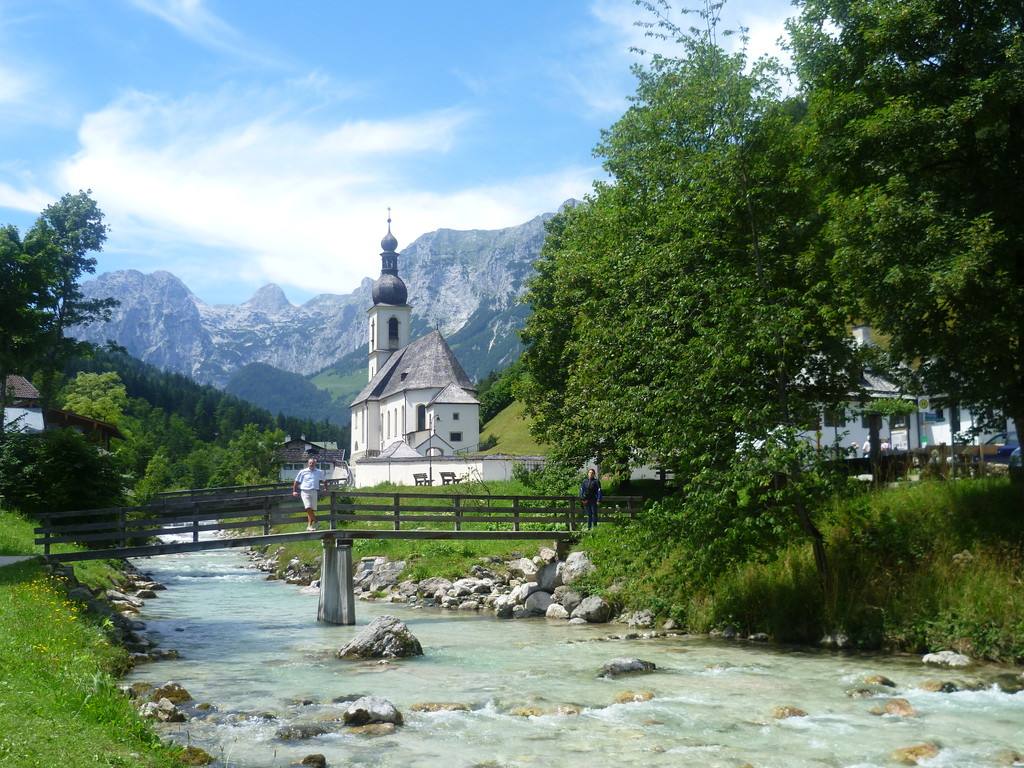 Die Kirche von Ramsau an einem Bach mit Bergkulisse