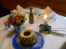 Festlich gedeckter Frühstückstisch mit Guglhupf und Blumen
